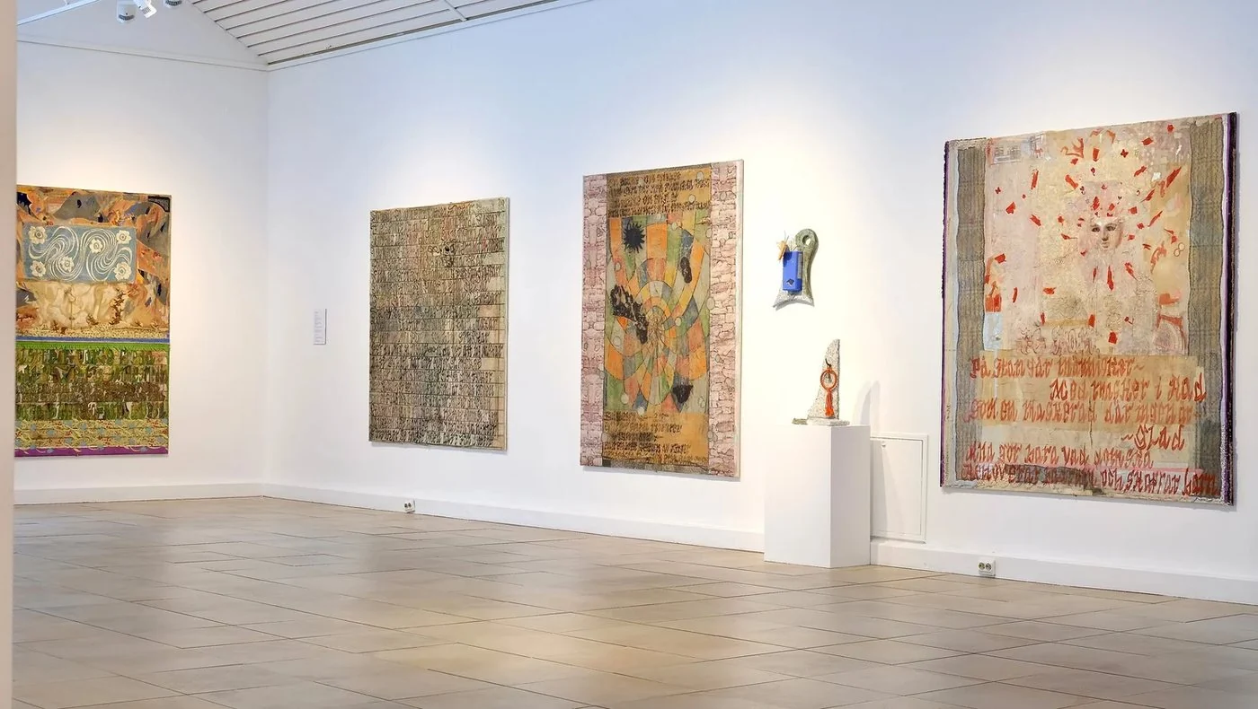 Målningar och skulpturer i en ljus museisal
