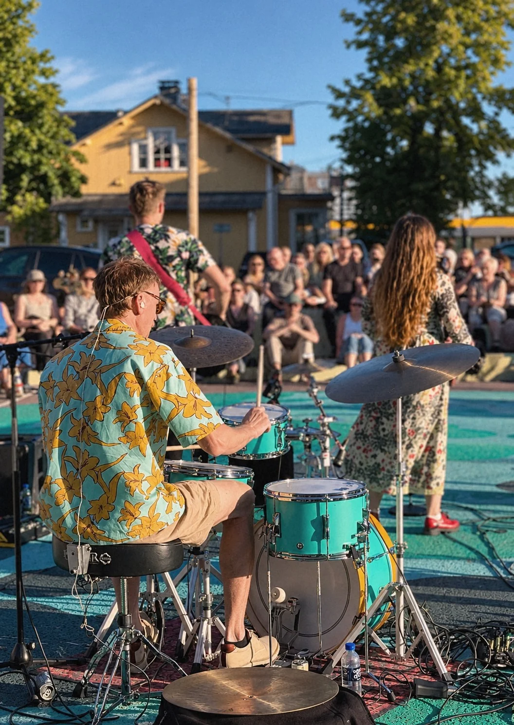 Ett band spelar på den målade markytan inför en sittande publik